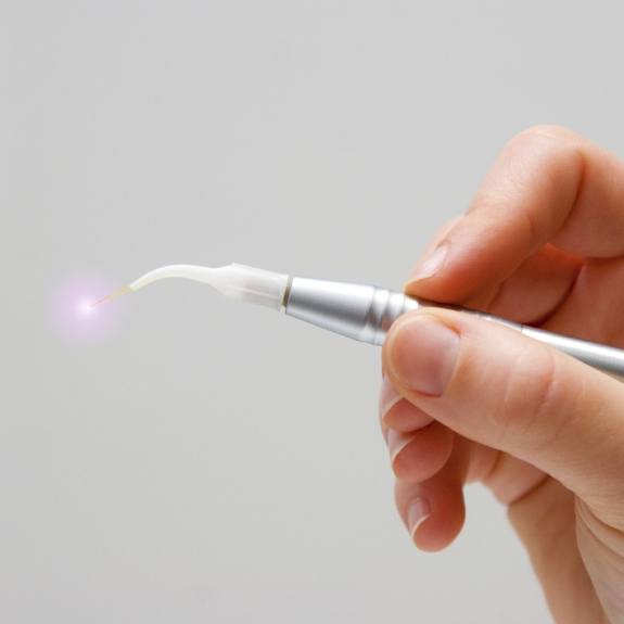 Hand holding a soft tissue laser dentistry tool