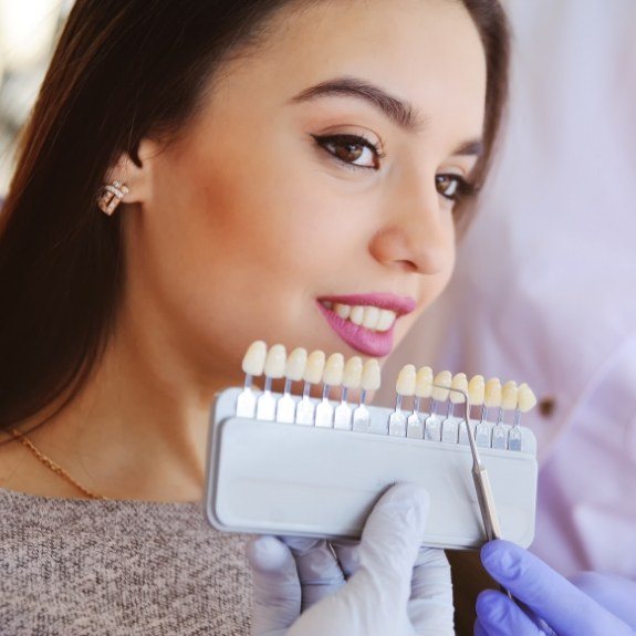 Woman's smile compared with veneers color options