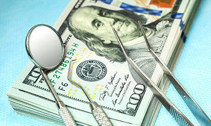 Dental instruments on top of stacks of cash