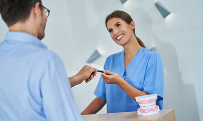 Man paying for his dental treatment at the front desk