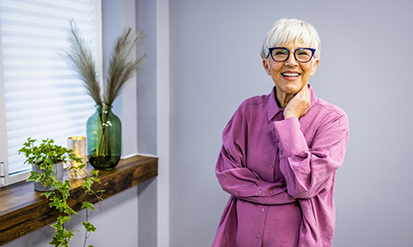 Smiling senior woman in a pink buttoned blouse