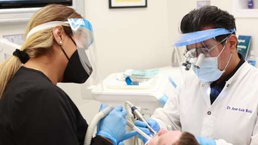Doctor Ruiz and a dental assistant treating a patient