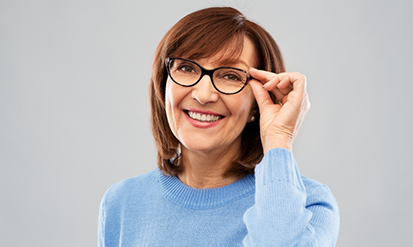 Smiling brunette woman adjusting her glasses
