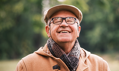 Senior man in glasses smiling outdoors