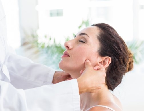 Dentist touching a woman's jaw