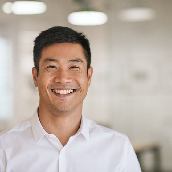 Man in white button-up shirt standing and smiling