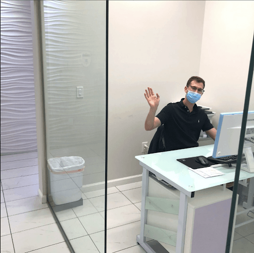 Waving dental team member at reception desk