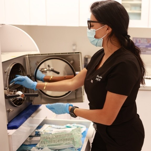 Dental team member sanitizing dentistry tools