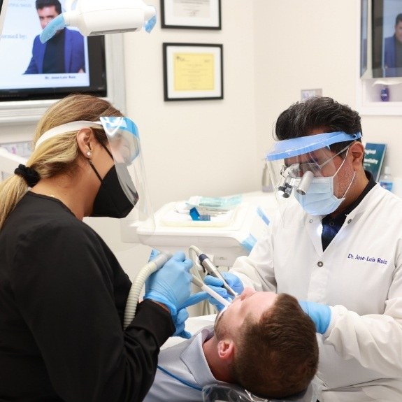 Dentist and dental team member treating dentistry patient