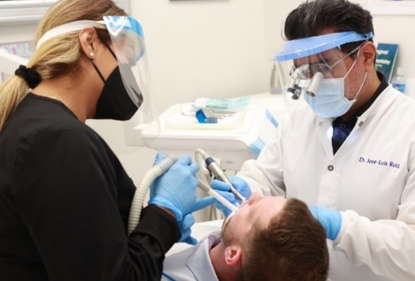 Doctor Ruiz and a dental assistant treating a patient