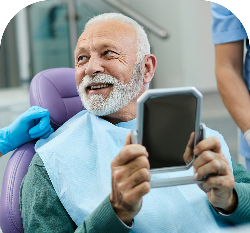 Senior man in the dental chair holding a mirror