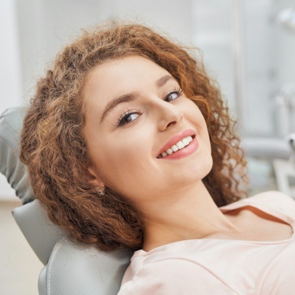 Woman smiling during gum disease treatment visit