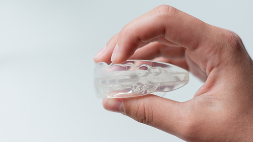 Hand holding a clear nightguard