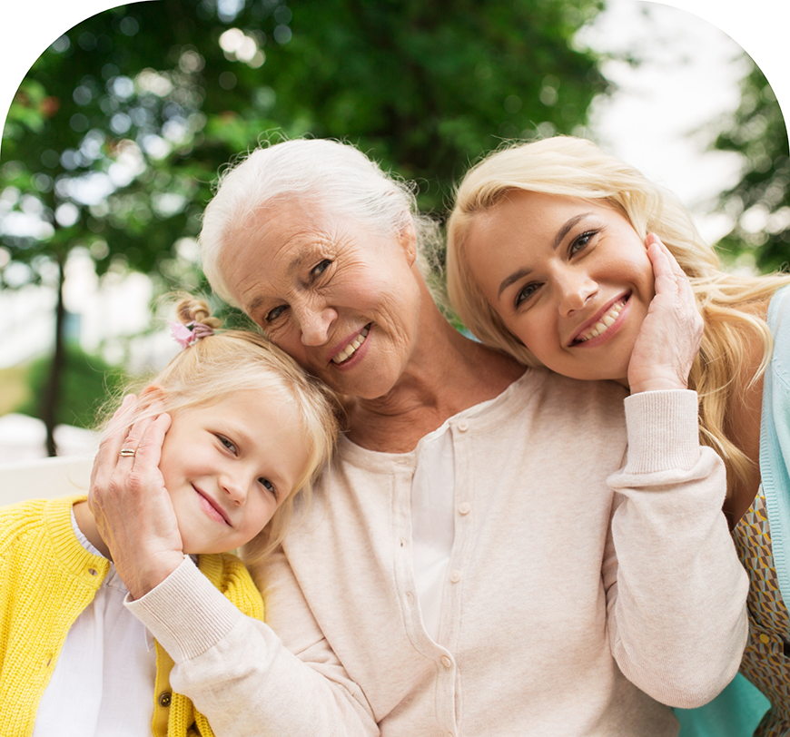 Senior woman smiling outdoors with her daughter and granddaughter