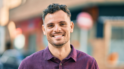 Smiling man in a purple collared shirt
