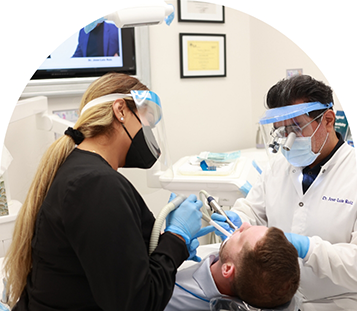 Doctor Ruiz and an assistant performing a dental procedure on a patient
