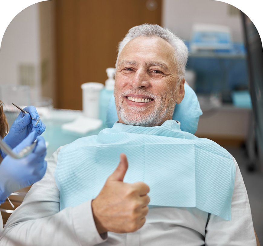 Senior man giving a thumbs up in the dental chair after supra-gingival dentistry in Burbank