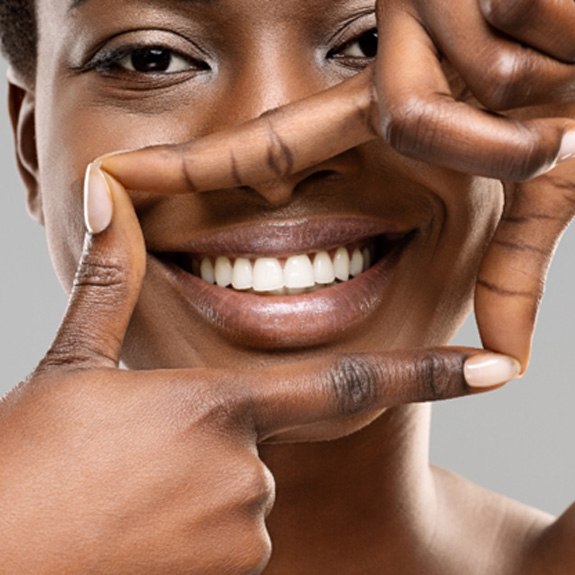Woman using her fingers to frame her beautiful smile