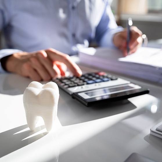 a man using a calculator and writing in a binder