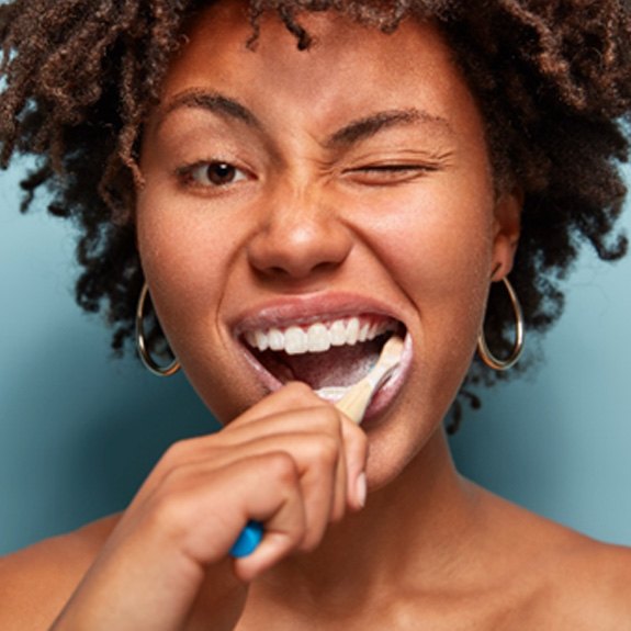 A closeup of a woman brushing her teeth