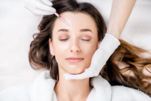a woman calmly getting BOTOX injections for her chronic migraines