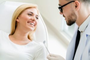 Smiling dentist talking with patient