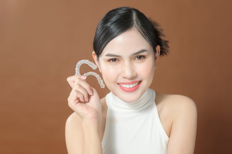 Smiling lady shows off her clear aligners